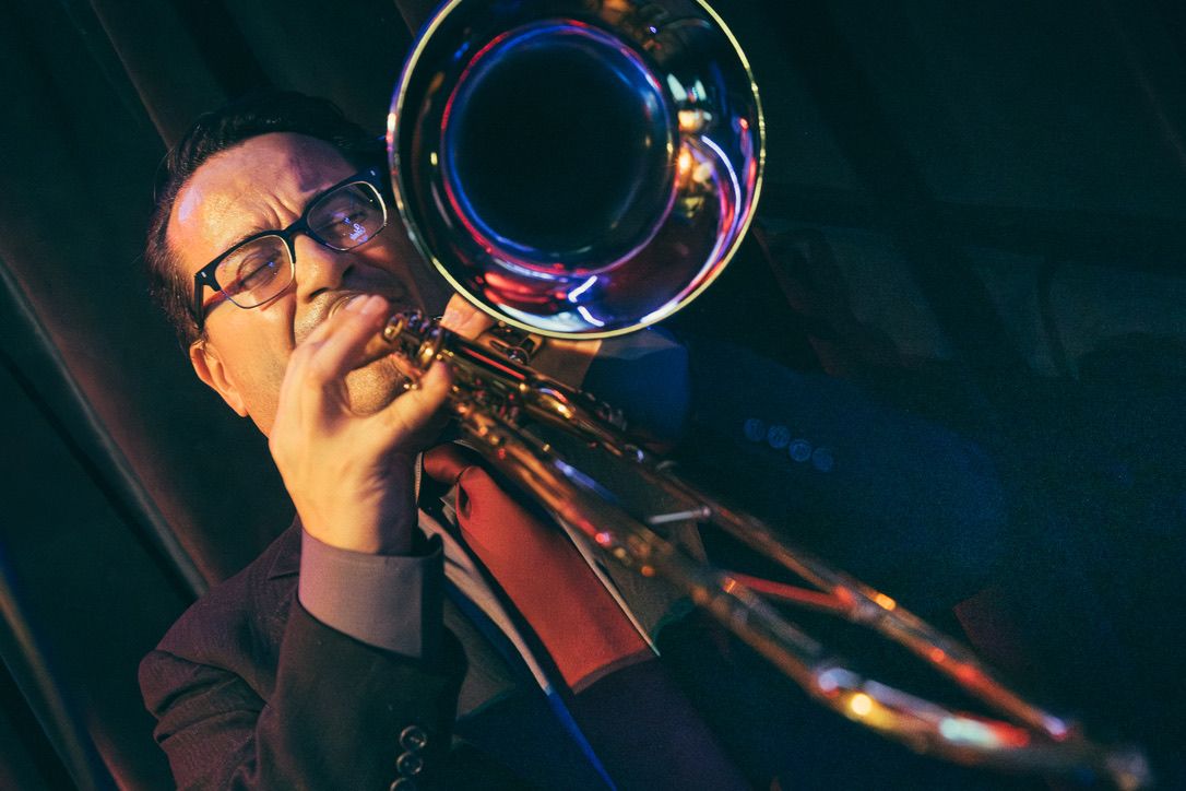 Trombonista de Guajirón tocando bajo luces azules y rojas