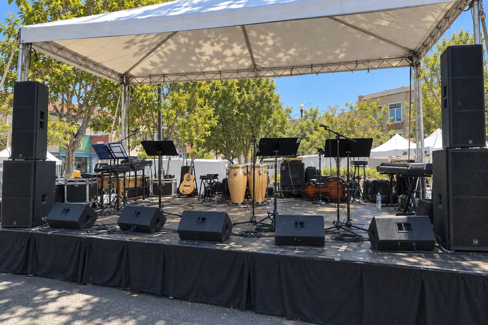 Illustrative outdoor stage setup with five wedge monitors and larger side speakers.